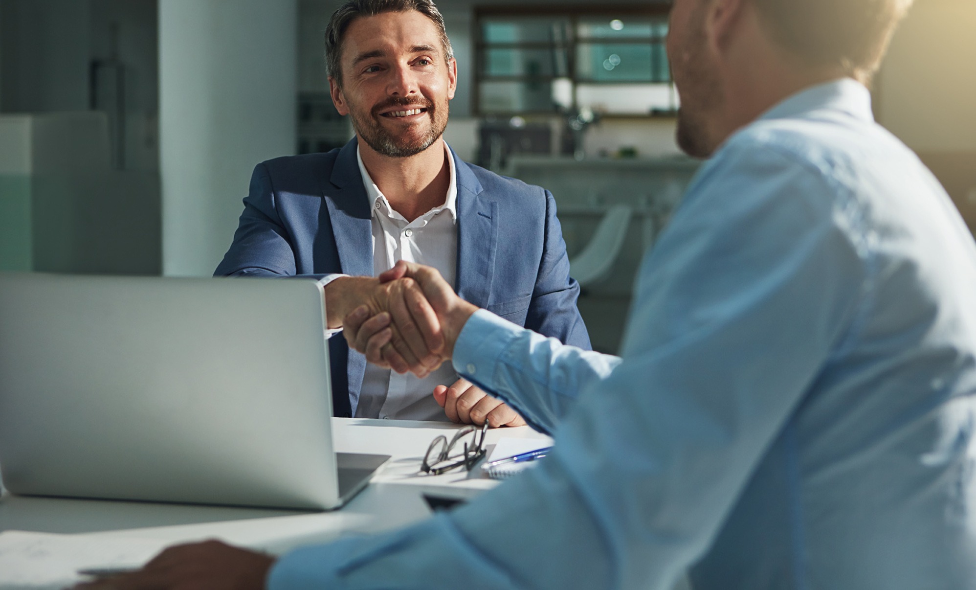 Foto de asesor con un cliente dándose la mano